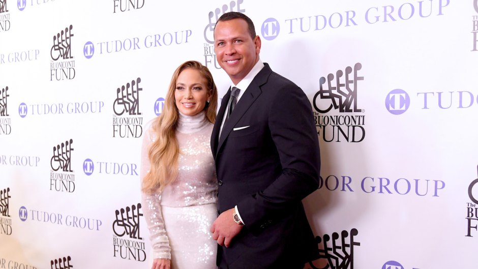Jennifer Lopez and Alex Rodriguez at an event in NYC, J.Lo wearing a white dress and A-Rod wearing a suit
