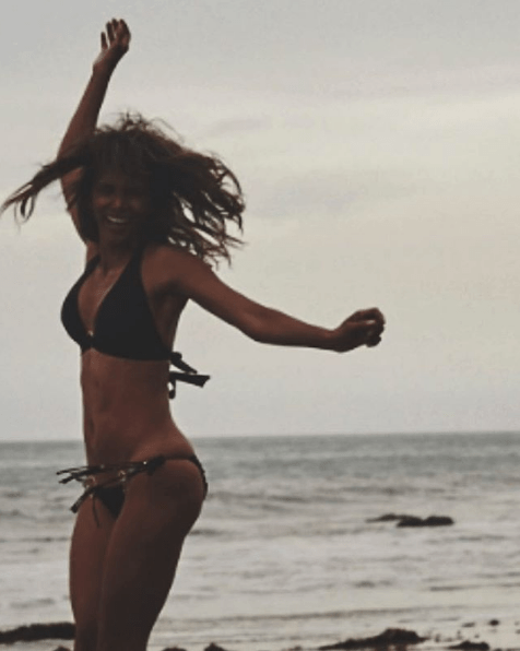 Halle Berry jumping for joy on a beach