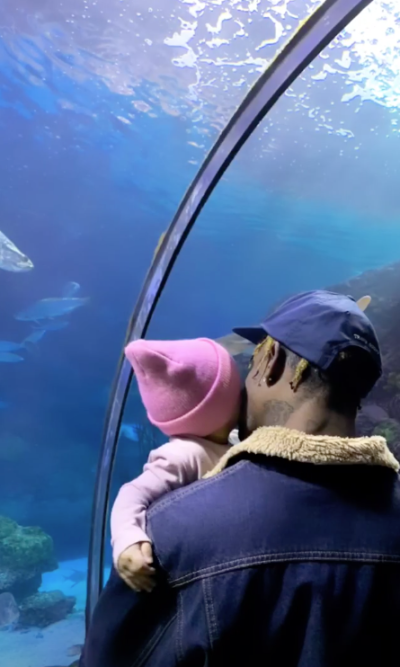 Travis Scott and Stormi Webster at the aquarium Stormi wearing a pink beanie