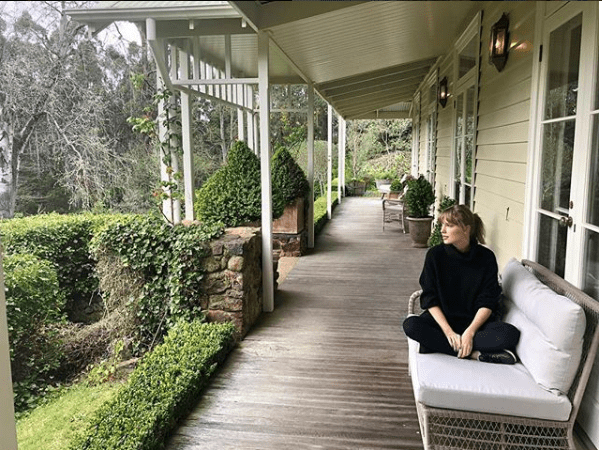 Taylor swift sitting on a porch