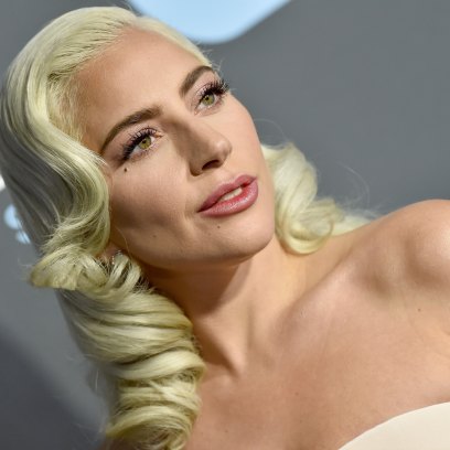 Upclose shot of Lady Gaga with curled blonde hair and a nude pink dress