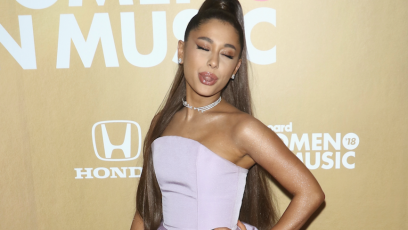 Ariana Grande sticking her tongue out wearing a purple dress
