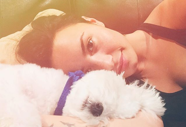 Demi Lovato laying down with her late dog Buddy