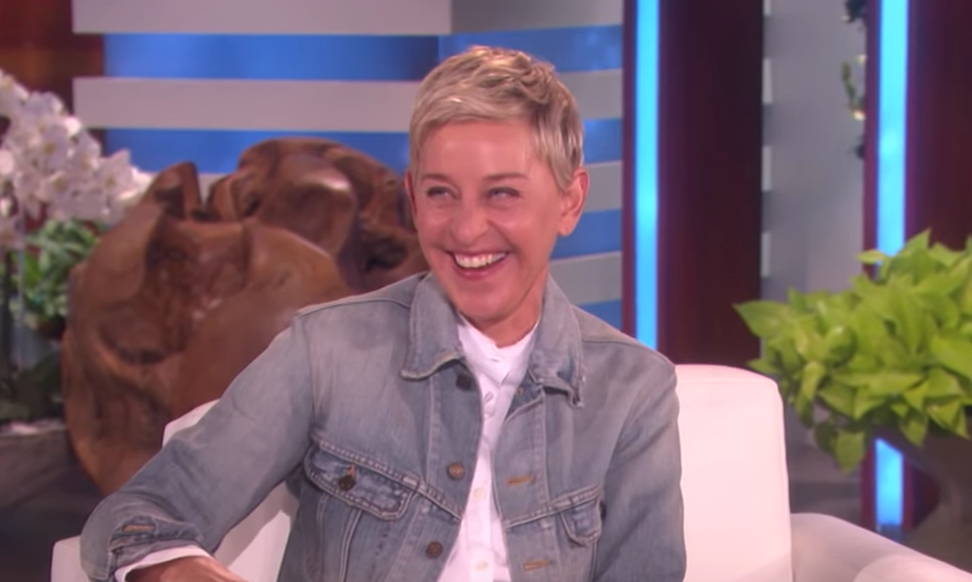 Ellen DeGeneres laughing wearing a jean jacket and white shirt