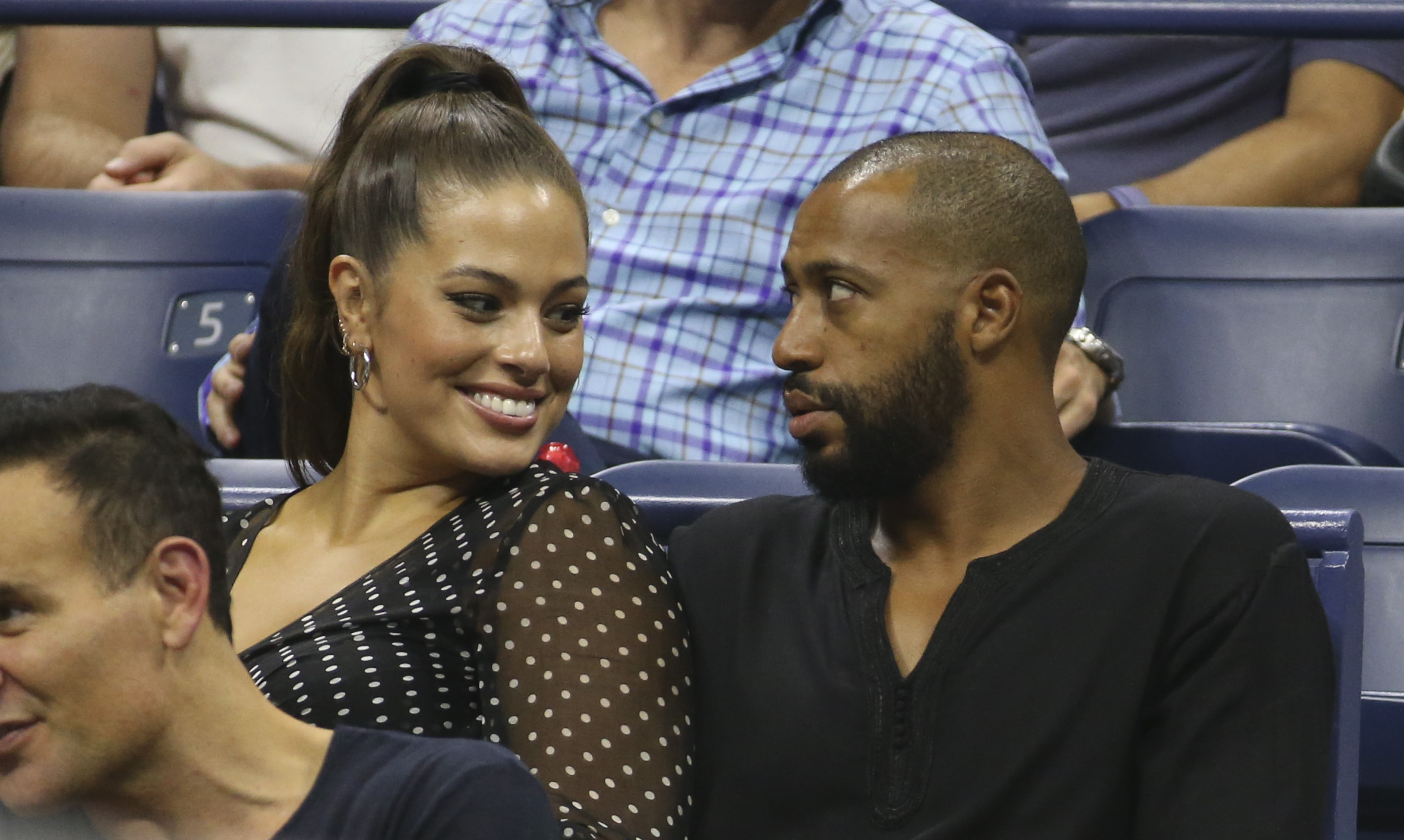 Ashley Graham sitting with husband Justin Ervin at the 2018 US open