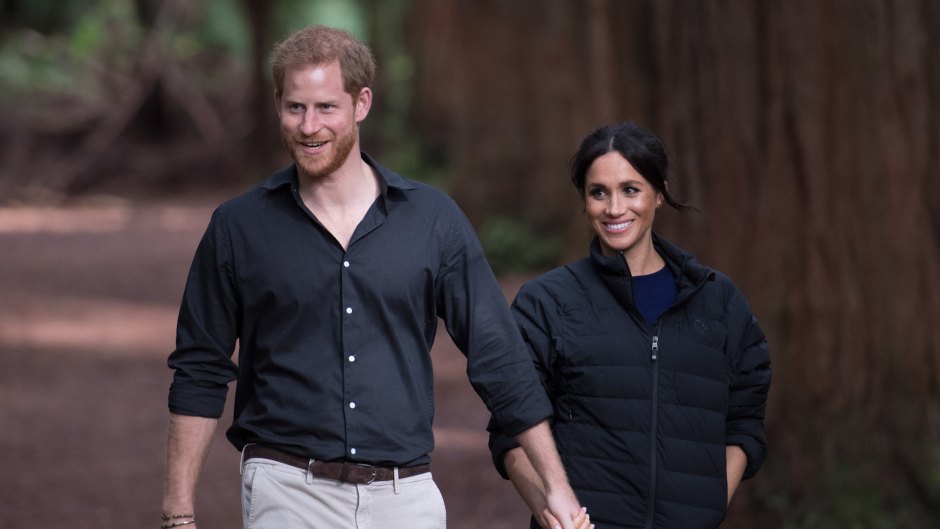 Prince Harry and Meghan Markle, wearing dark colors and holding hands