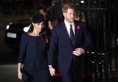 Meghan Markle wearing a dark blue dress with Prince Harry