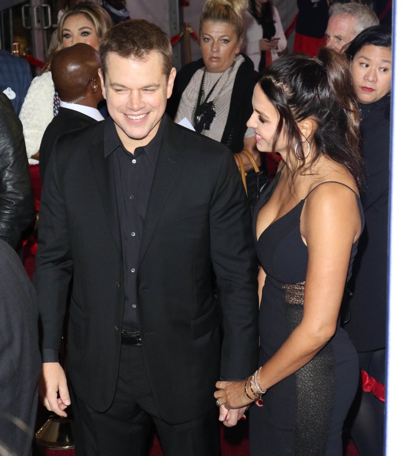 Matt Damon wearing a black suit holding hands with wife Luiciana