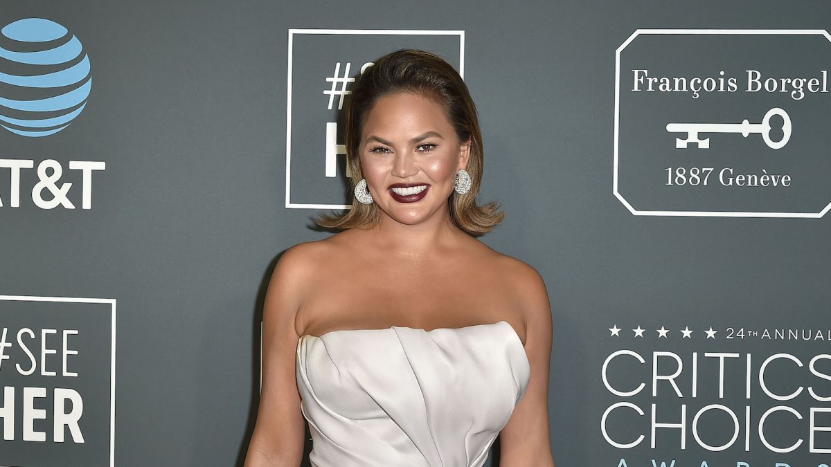 Chrissy Teigen wearing a white satin dress at Critics' Choice Awards