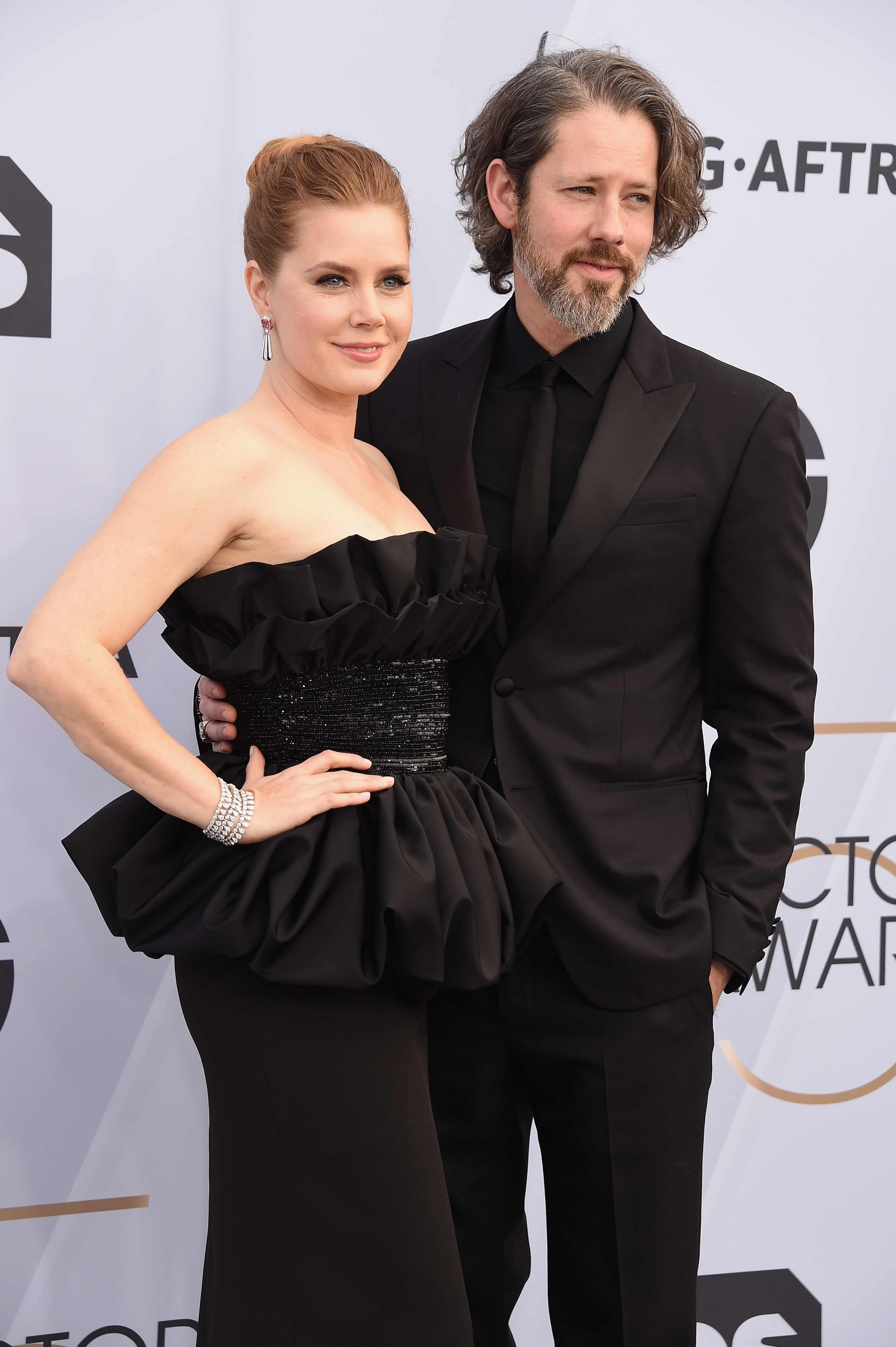 Amy Adams wearing black with her husband