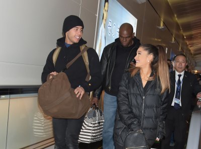 Ariana Grande Ricky Alvarez laughing in winter coats walking through the airport