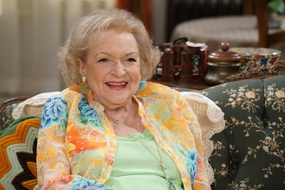 Betty White smiling wearing a floral blazer and green top 