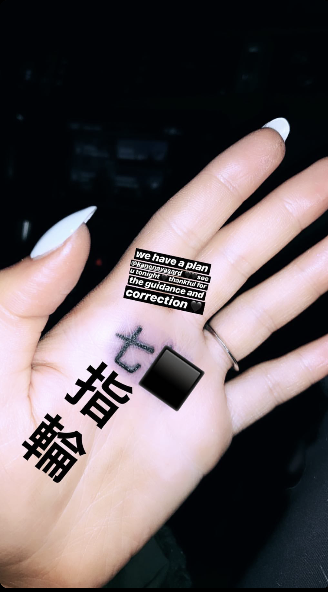 Ariana Grande fixing her hand tattoo