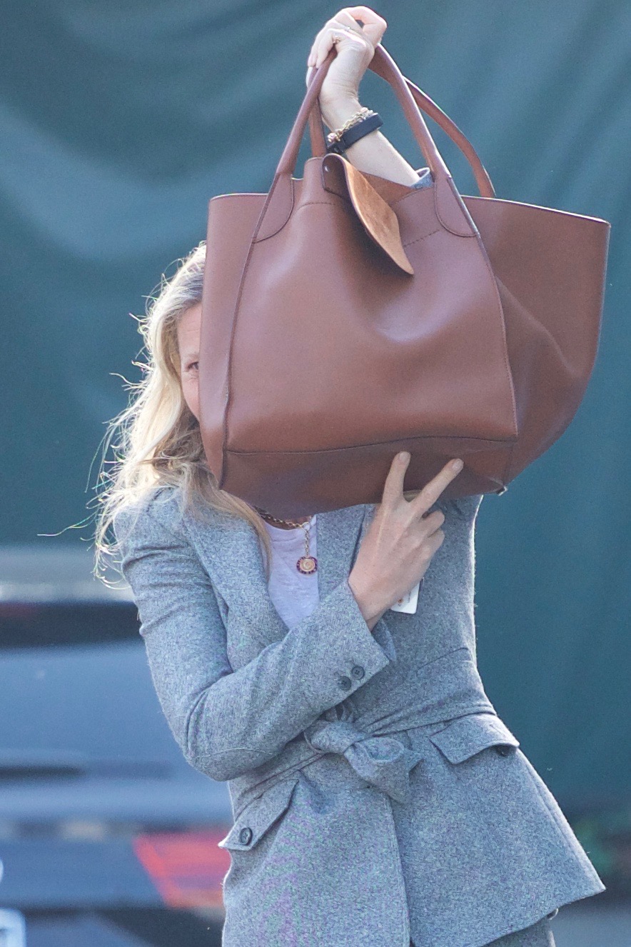 Gwyneth Paltrow trying to hide her face with her bag