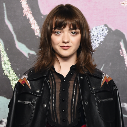 Maisie Williams posing in a black jacket with straight hair and bangs