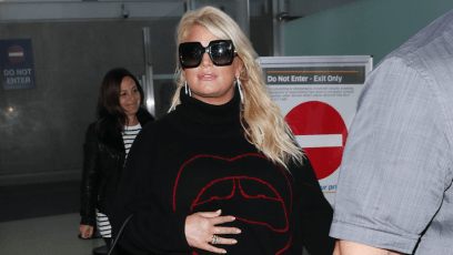 Jessica Simpson pregnant walking in the airport wearing black sunglasses and a sweater