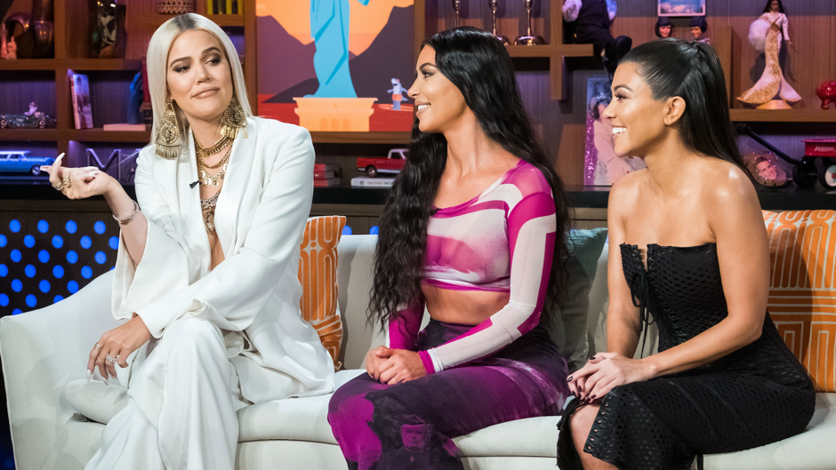 Khloe, Kim, and Kourtney Kardashian sitting on a couch during Andy Cohen's Watch What Happens Live