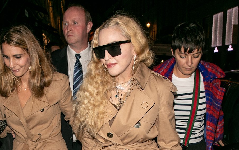 Madonna walking in Paris in a beige coat with black sunglasses