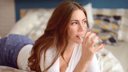 young beautiful woman drinks water from a glass