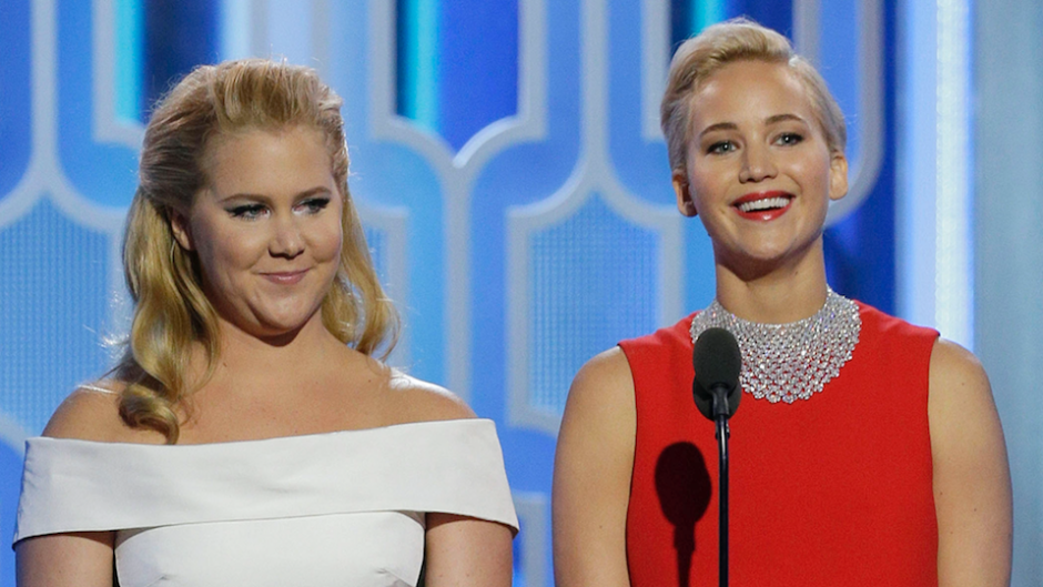 Amy Schumer and Jennifer Lawrence standing on stage