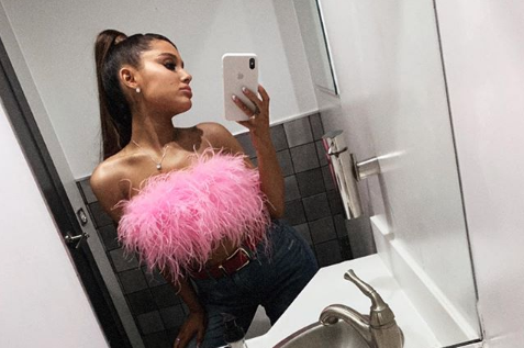 Ariana Grande taking a selfie in a fuzzy pink top