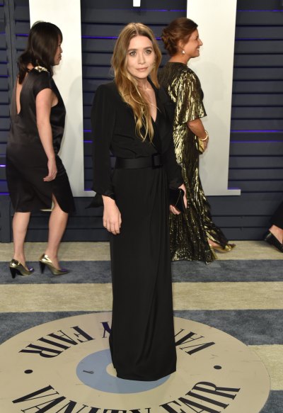 Ashley Olsen posing in a black dress with her hair down