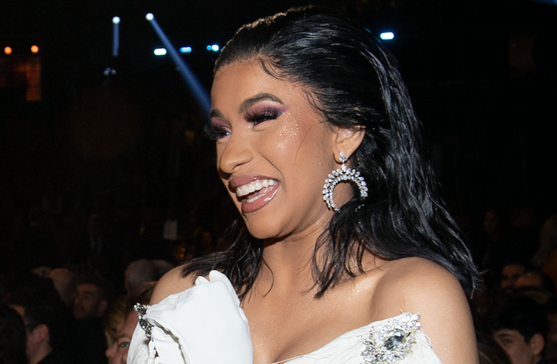 Cardi B smiling in a white dress at the 2019 Grammy Awards