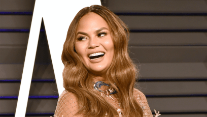 Chrissy Teigen looking over her shoulder and smiling at the 2019 Oscars