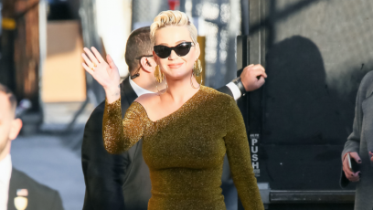 Katy Perry wearing a tight, gold dress with black sunglasses