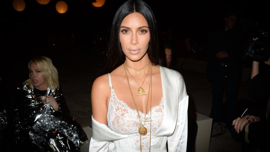 Kim Kardashian at 2016 Paris Fashion Week wearing a white dress and gold necklaces