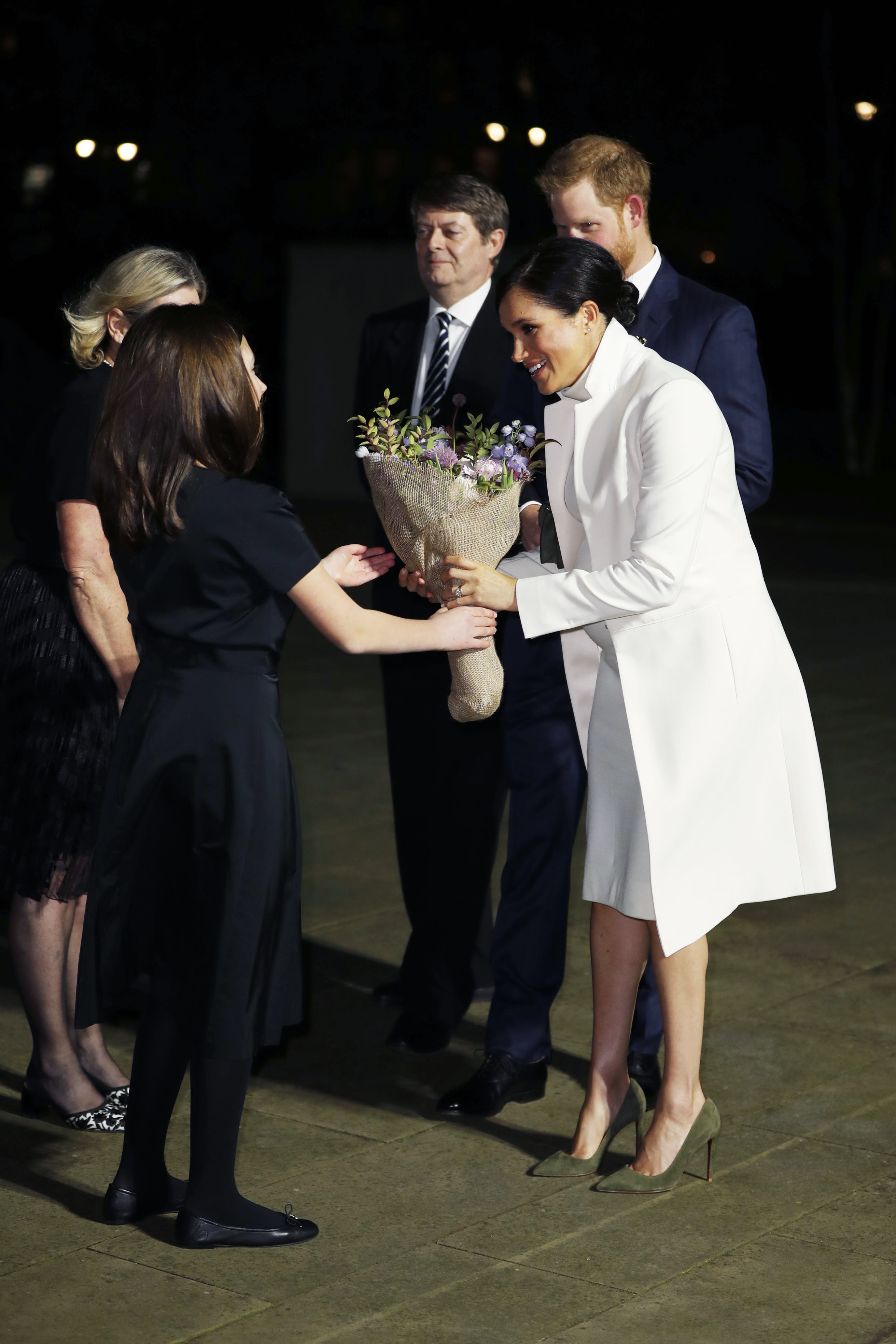 Meghan Markle in a white dress with Prince Harry in a navy suit