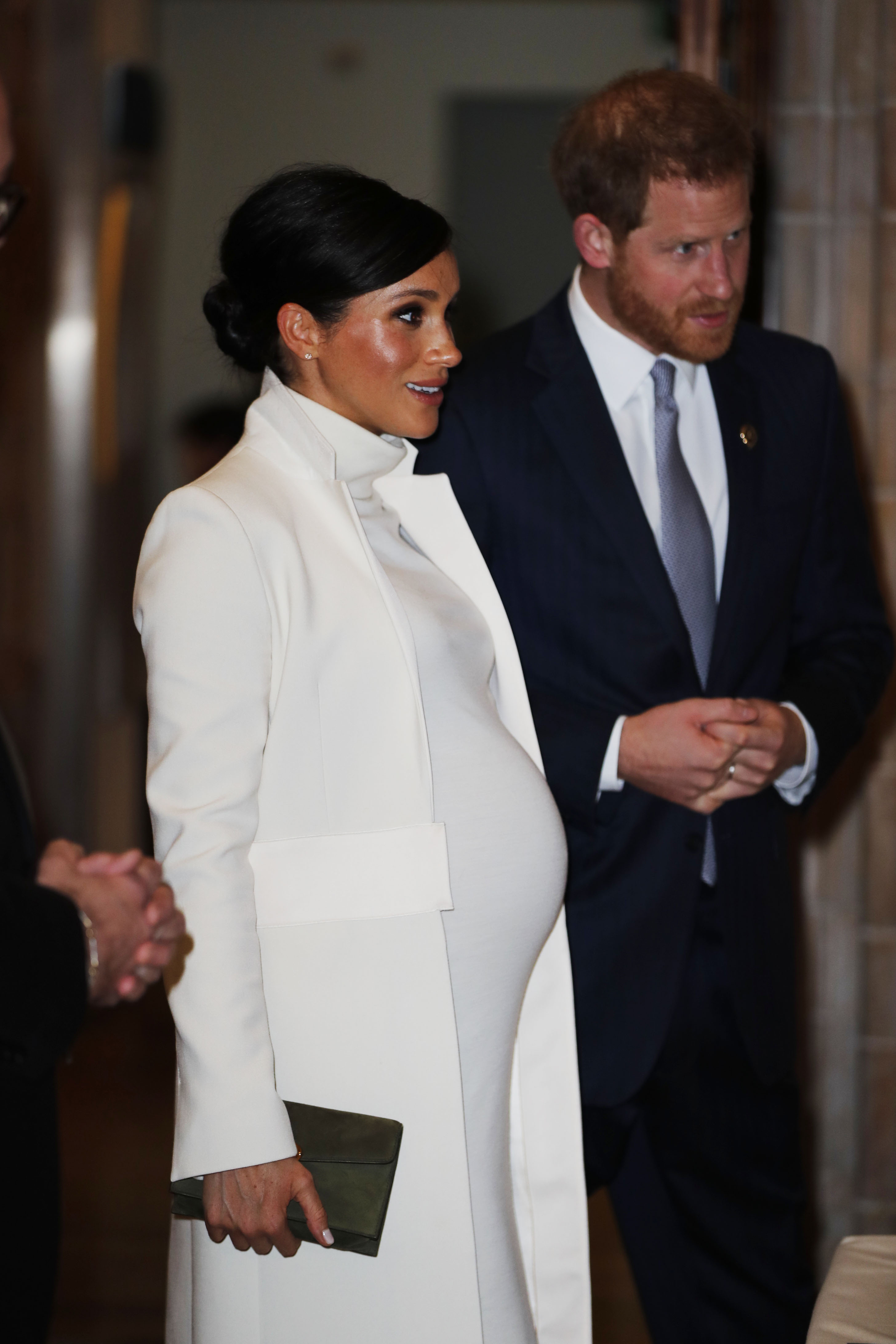 Meghan Markle in a white dress with Prince Harry in a navy suit