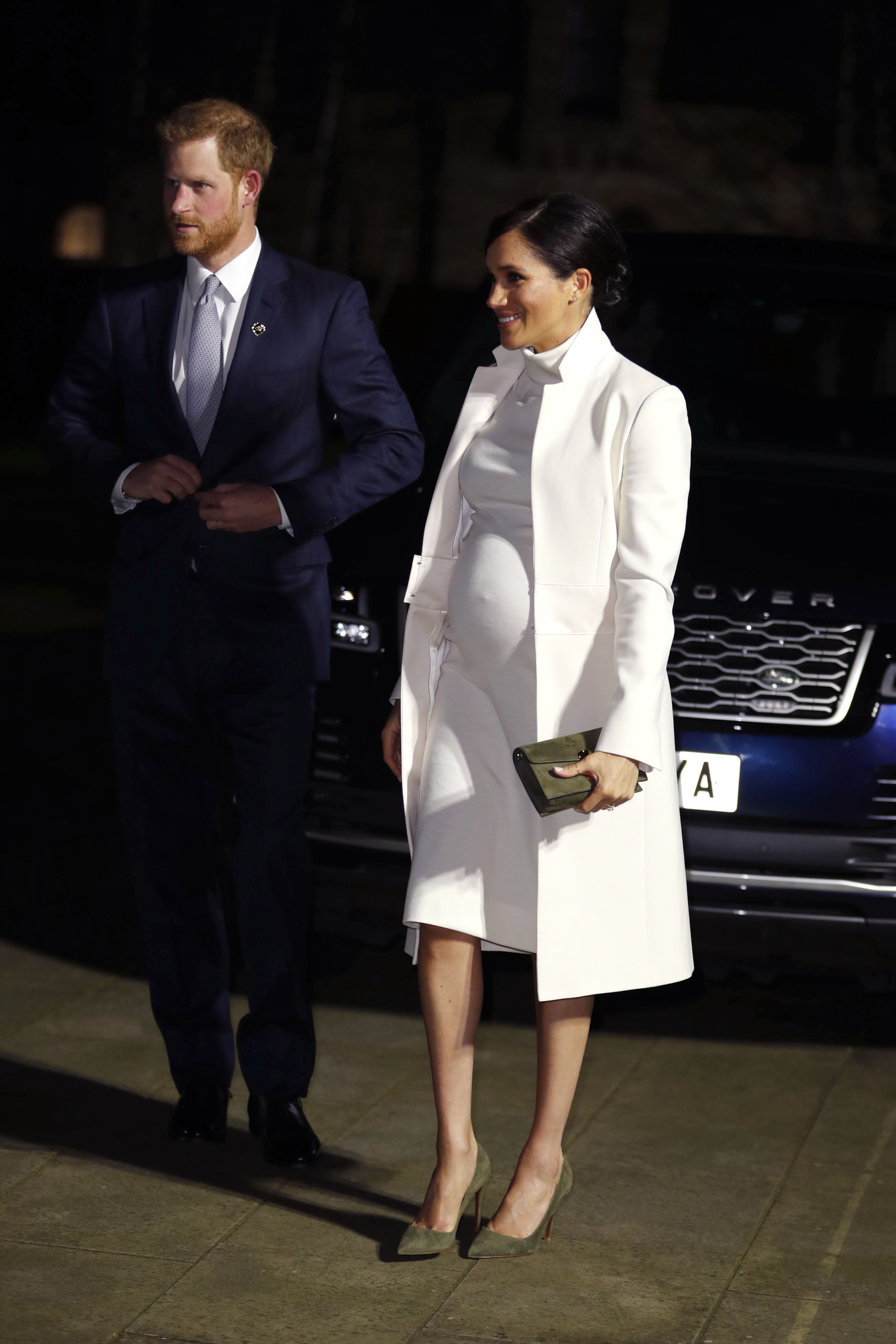 Meghan Markle in a white dress with Prince Harry in a navy suit