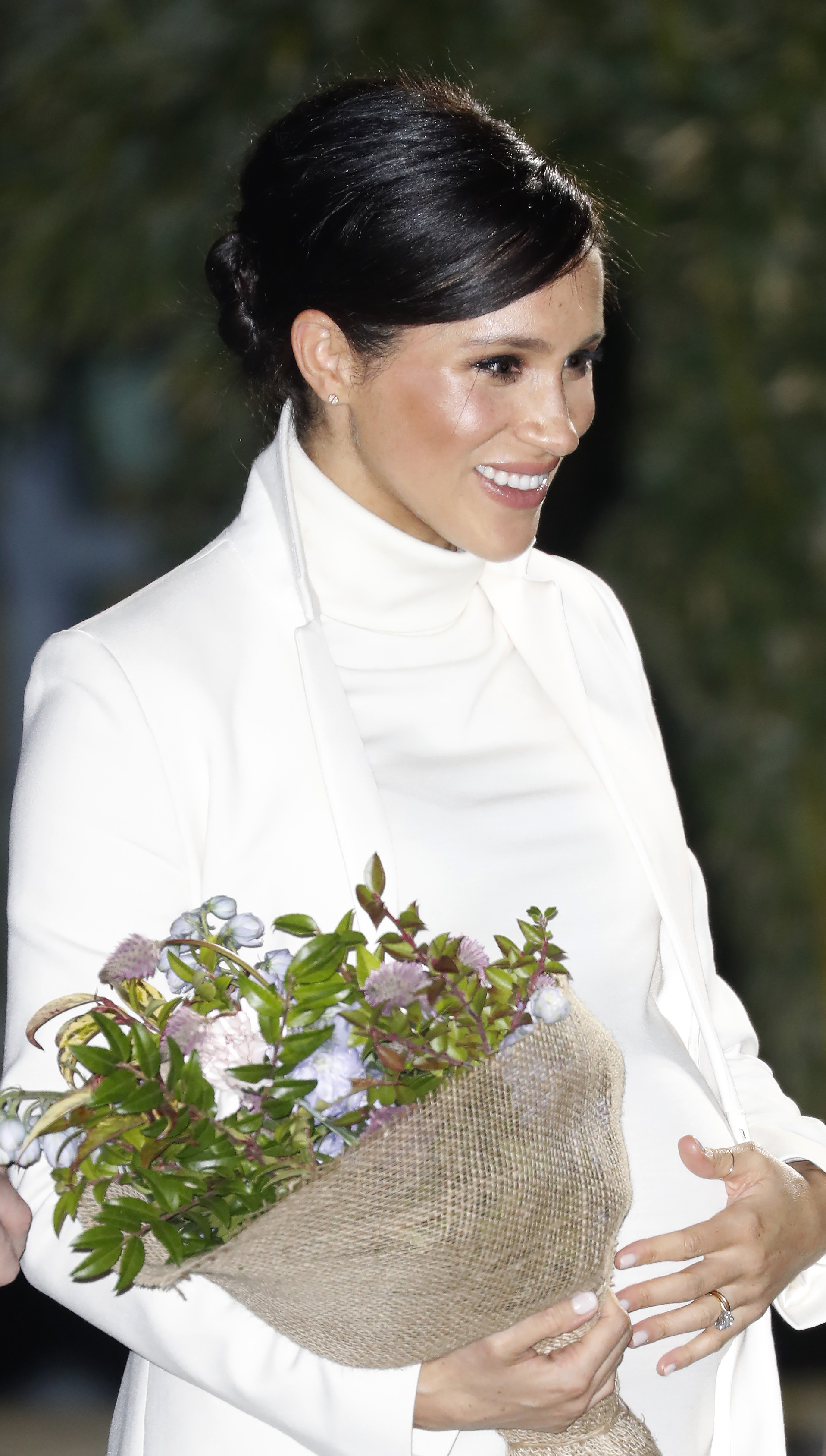 Meghan Markle in a white dress with Prince Harry in a navy suit