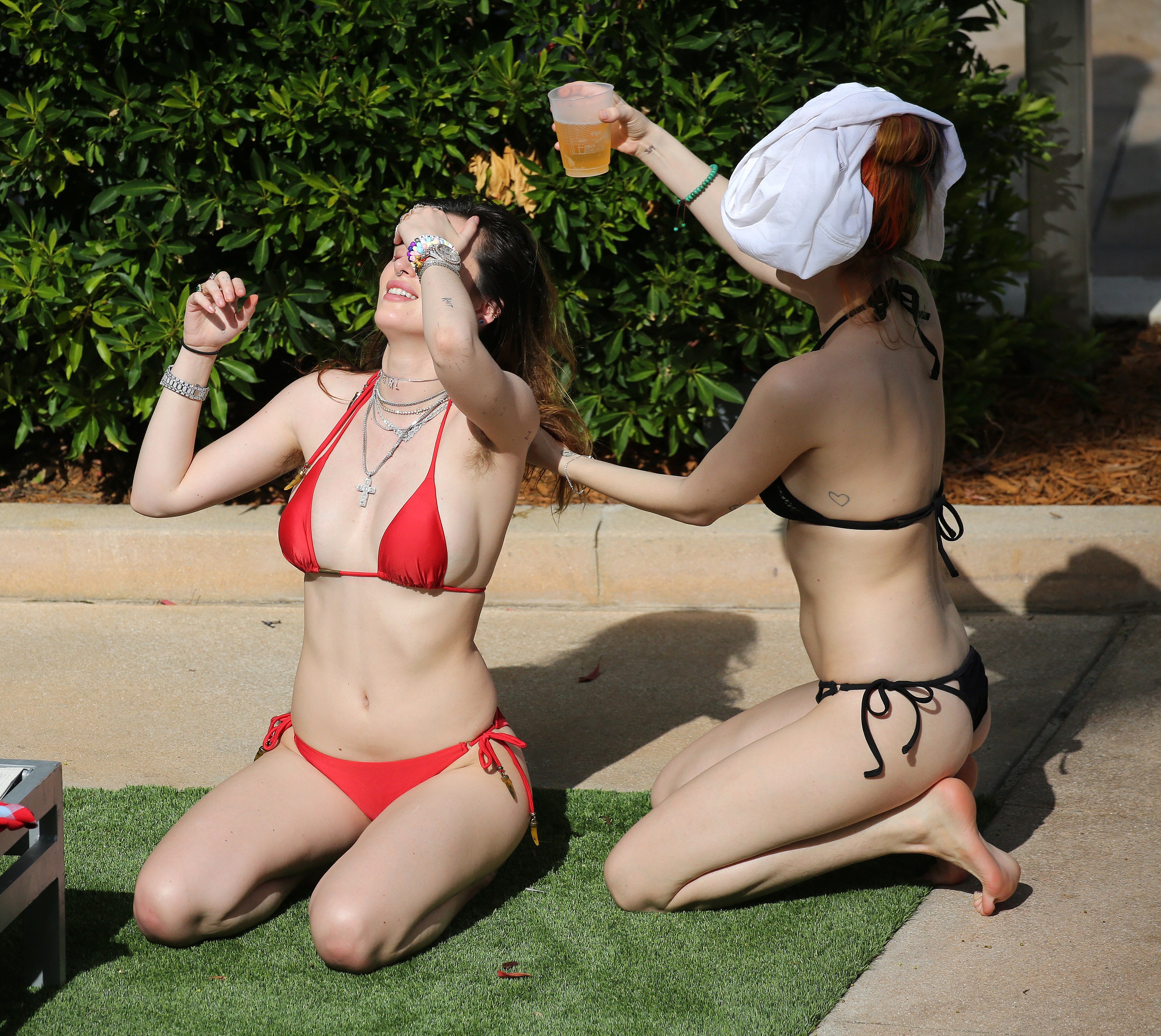 Bella Thorne in a tiny, red bikini with hairy armpits