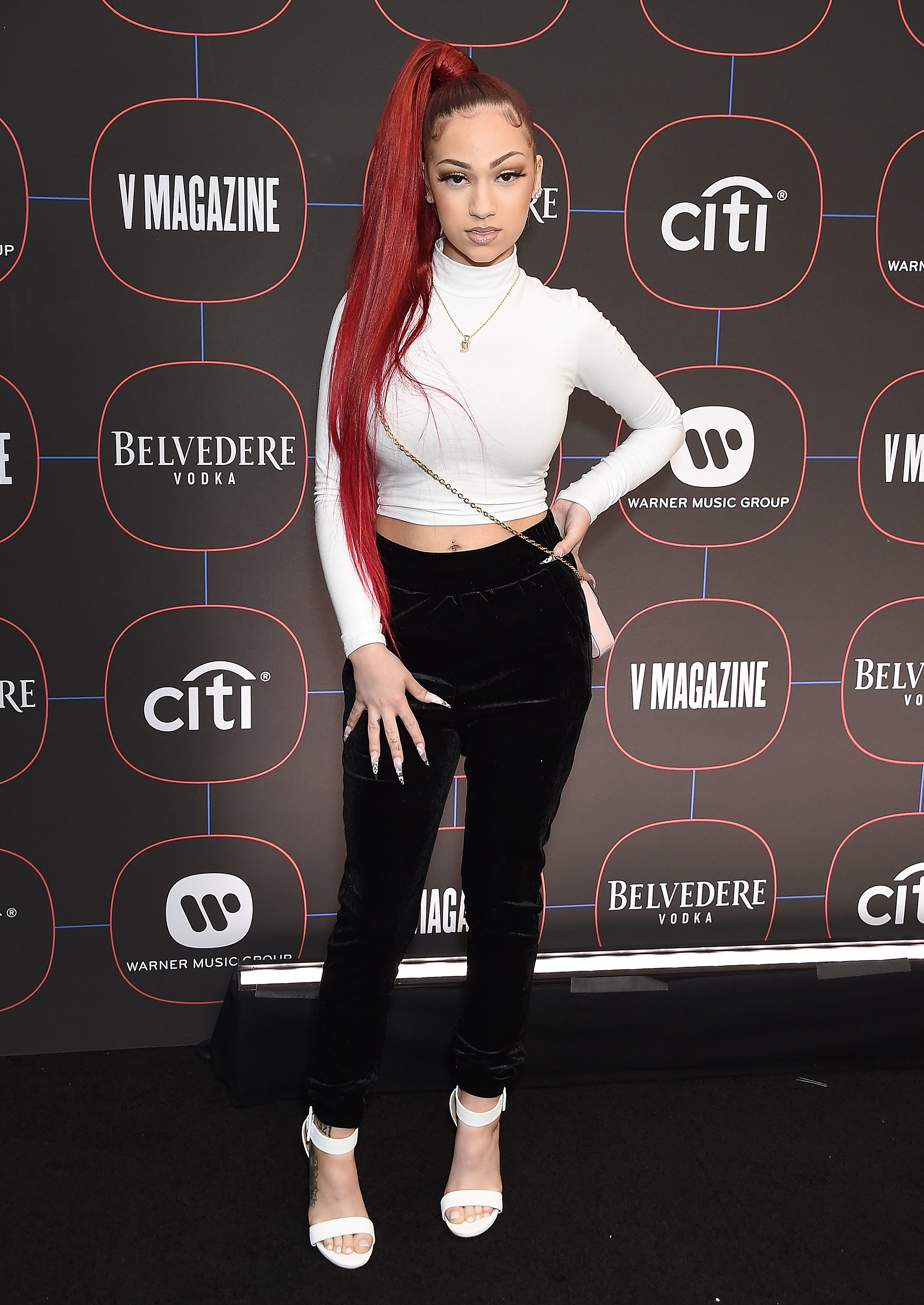 Bhad Bhabie posing in a white top and black pants