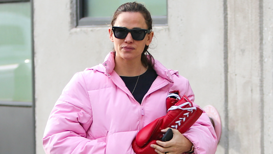 Jennifer Garner carrying boxing gloves wearing a puffy, pink jacket.
