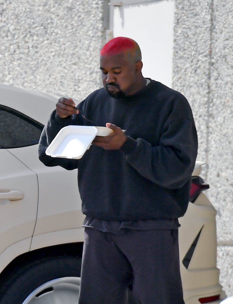 Kanye West walking and eating lunch