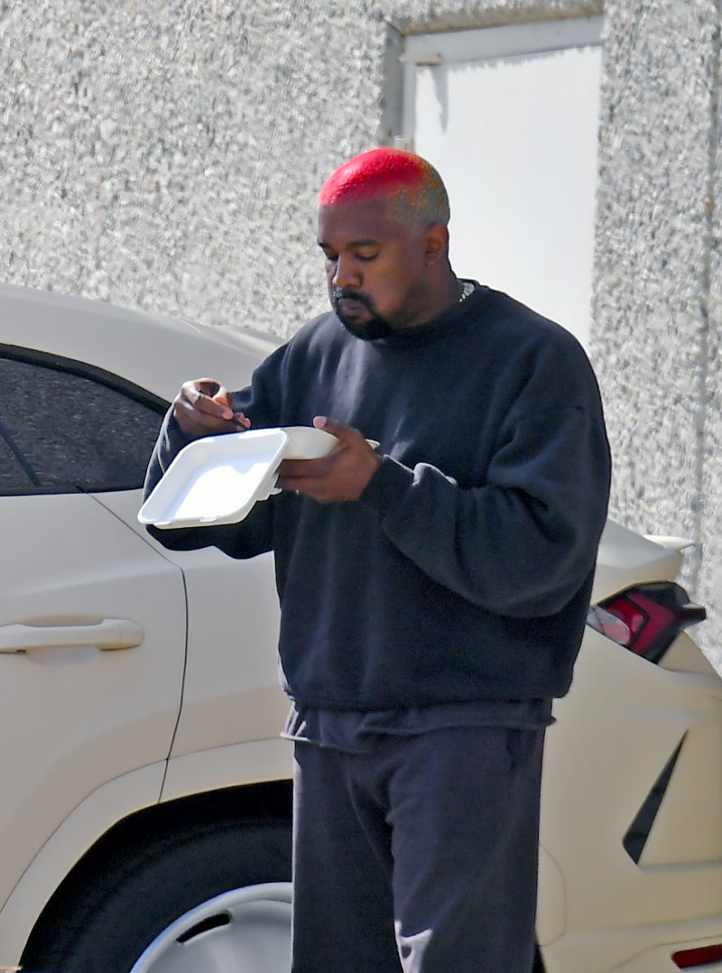 Kanye West walking and eating lunch