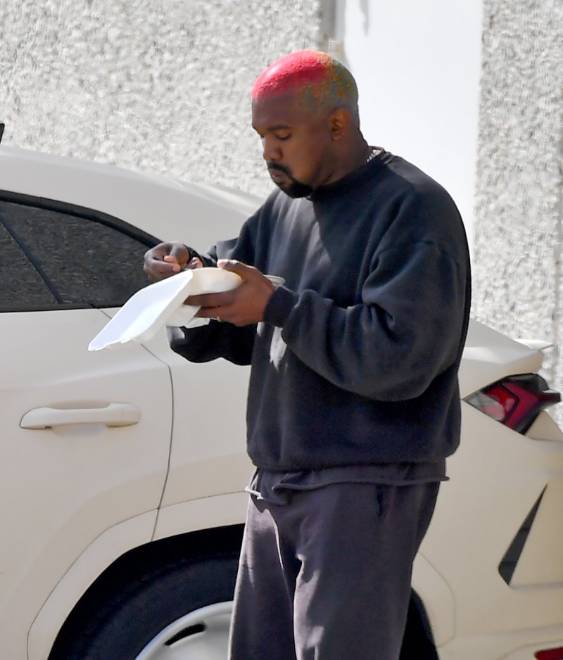 Kanye West walking and eating lunch