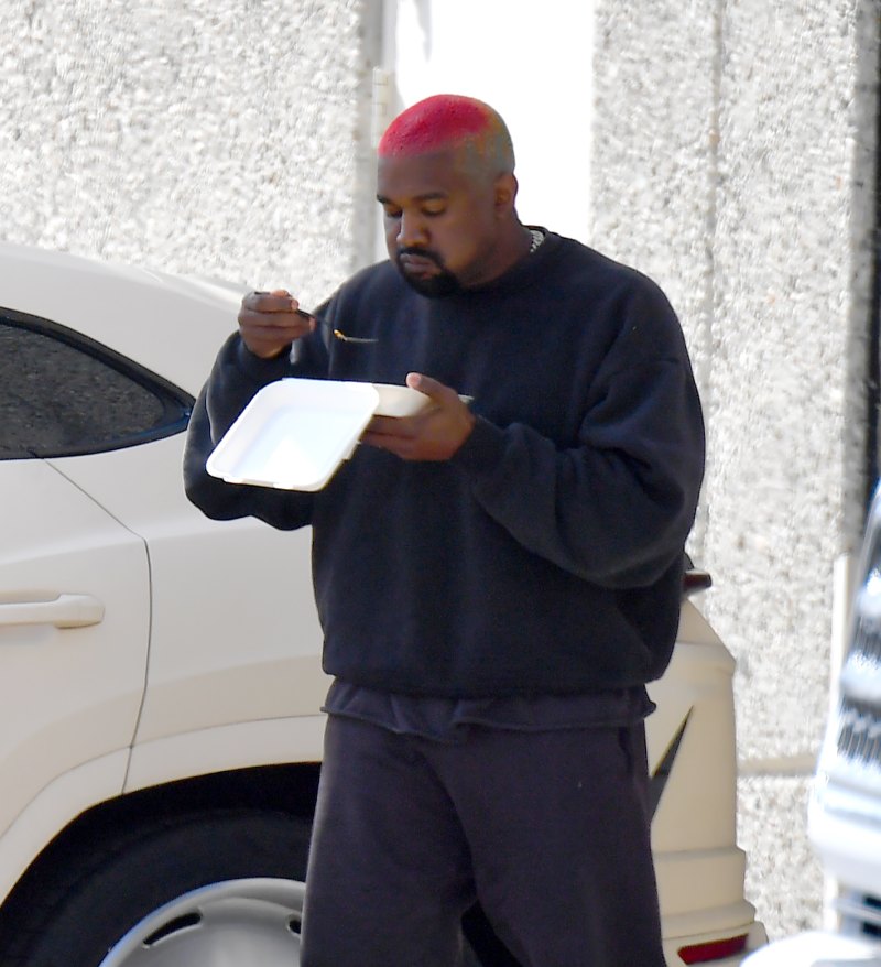 Kanye West walking and eating lunch