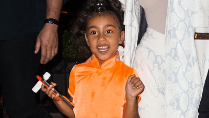 North West wearing an orange outfit walking in NYC