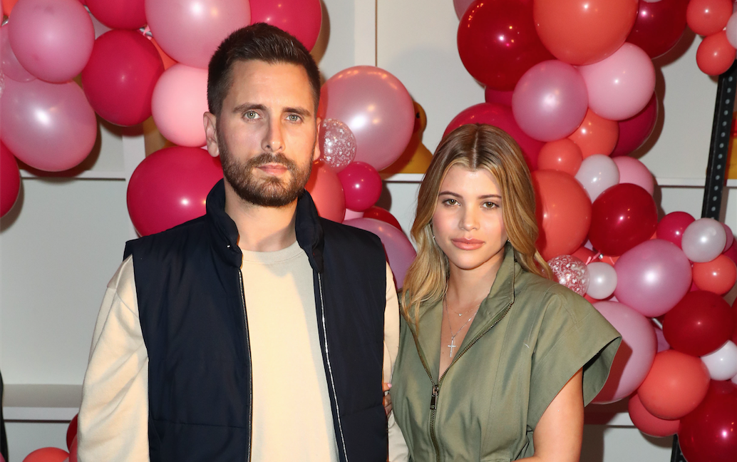 Scott Disick posing in front of balloons with Sofia Richie.