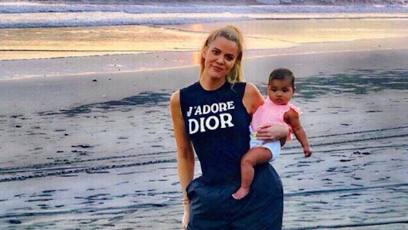 khloe kardashian carrying true with a sunset in the background