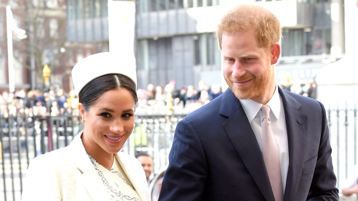 Meghan Markle white hat white coat Prince Harry suit holding hands
