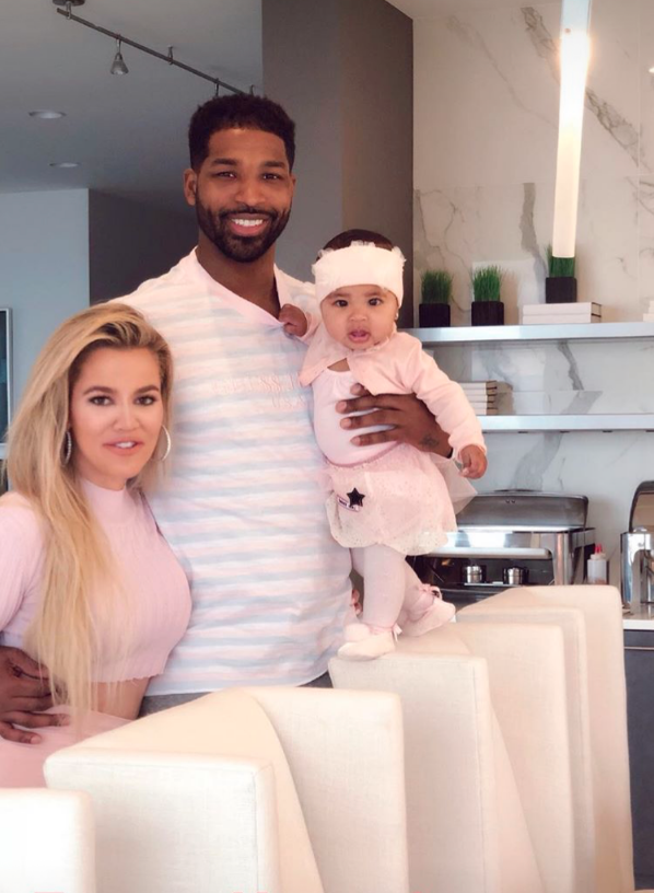 Khloe Kardashian posing with Tristan Thompson and baby True