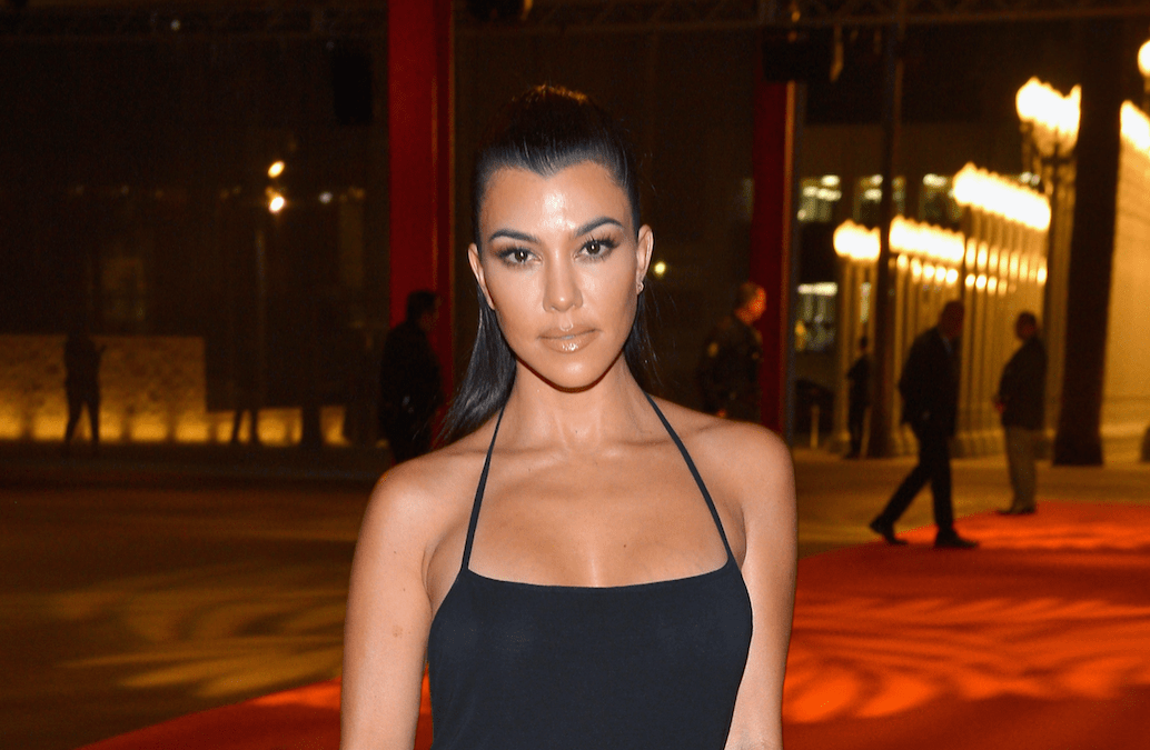 Kourtney Kardashian wearing a black dress on the red carpet.