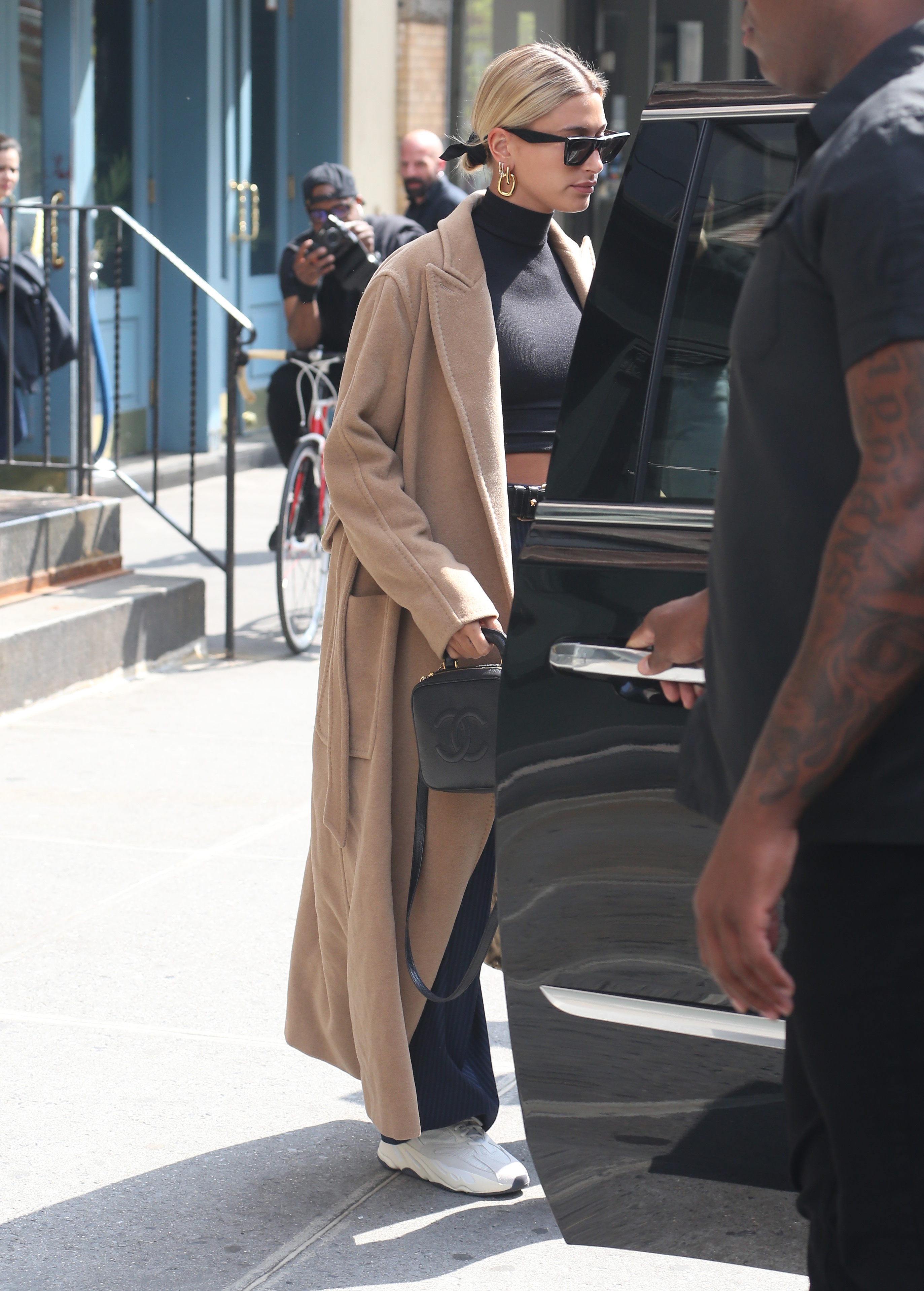 Hailey Baldwin black car long tan coat sunglasses