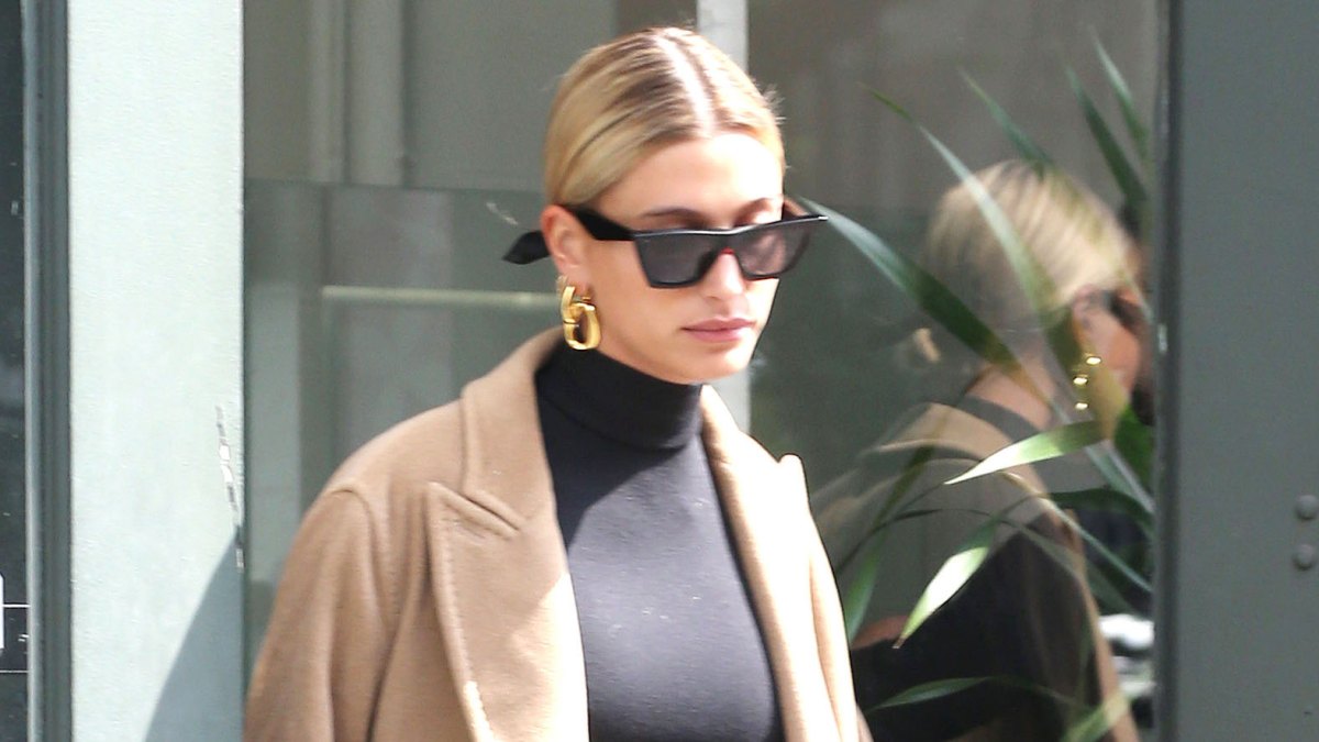 Hailey Baldwin street style black crop top sunglasses tan coat low bun