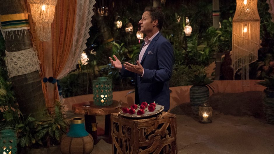 Bachelor Host Chris Harrison Stands on Bachelor in Paradise Rose Ceremony in Blue Suit Jacket and Pink Shirt Before a Rose Ceremony